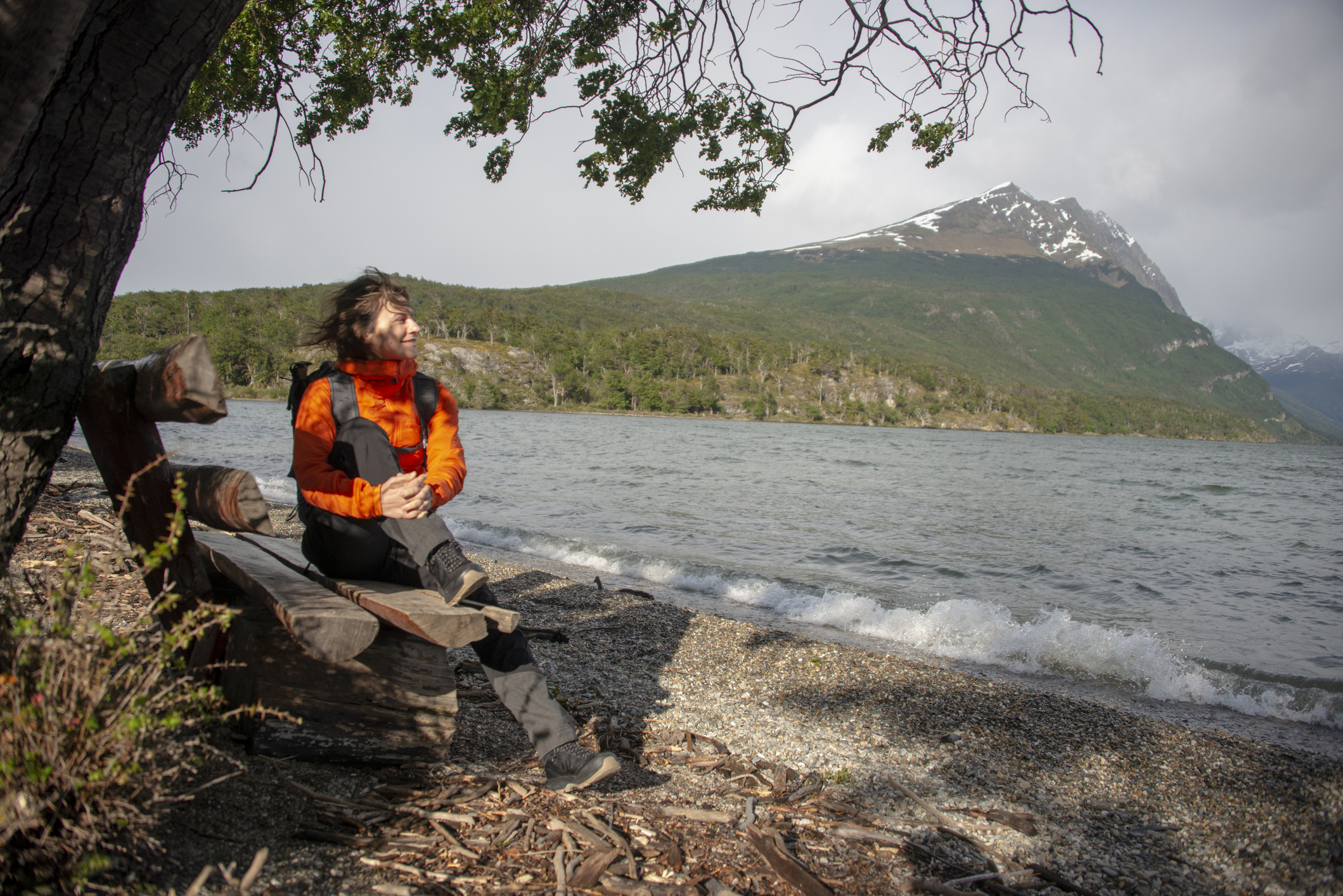 A female hiker rests on the bench on the shore of Lake Acigami