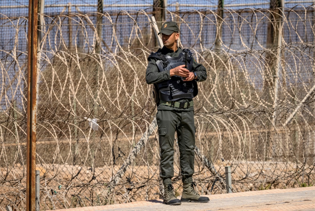 A Moroccan security officer on the border fence separating Morocco from Spain's North African Melilla enclave, pictured here in June