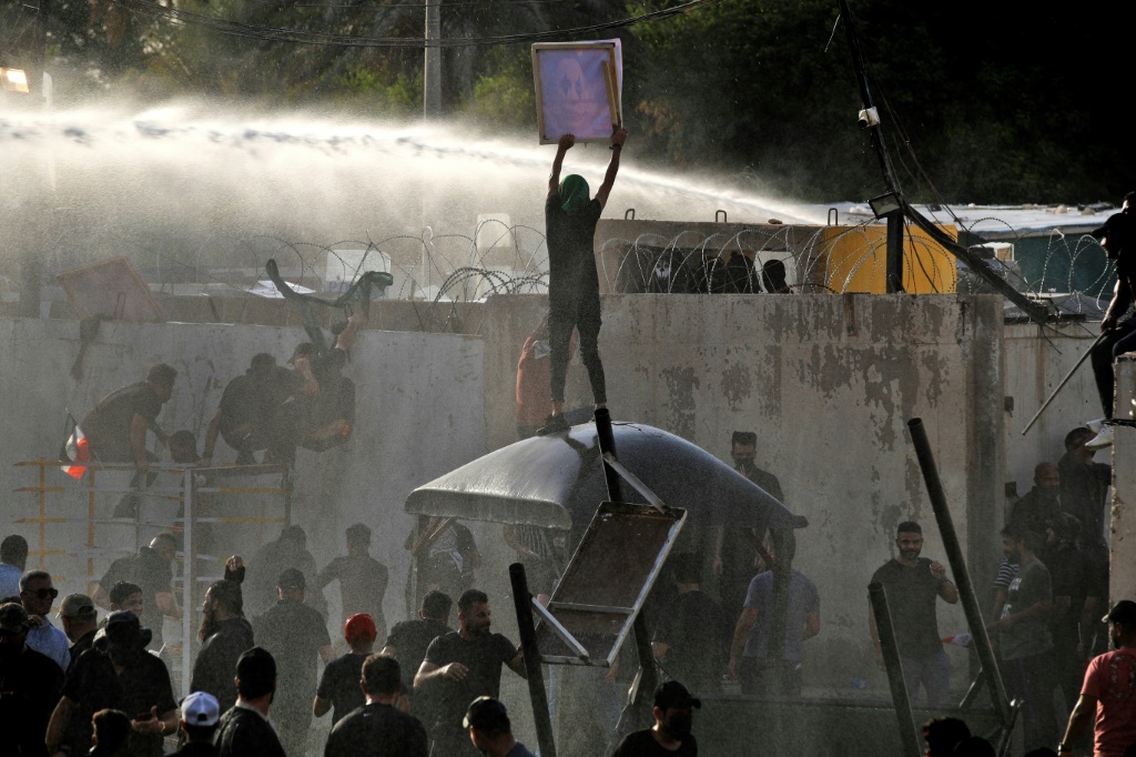 Iraqi security forces use a water cannon against supporters of the Coordination Framework to stop them entering the Green Zone on Monday