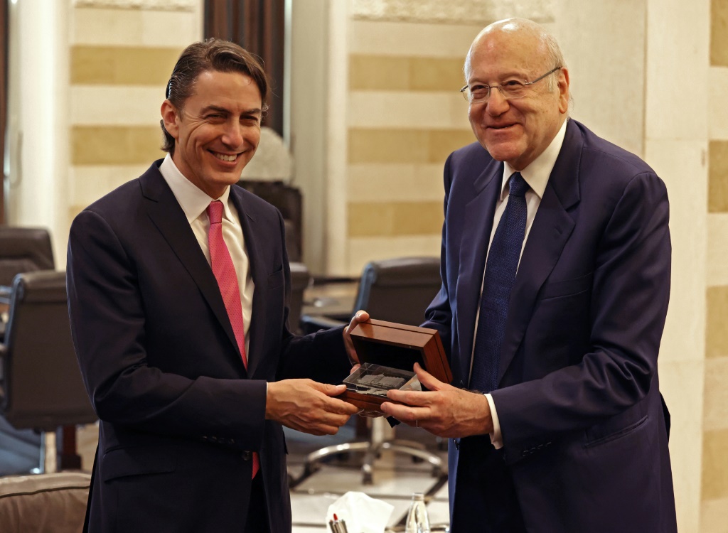 Lebanese Prime Minister Najib Mikati (R) presents US envoy Amos Hochstein (L) a gift depicting a hologram of the Lebanese government palace in Beirut on Thursday