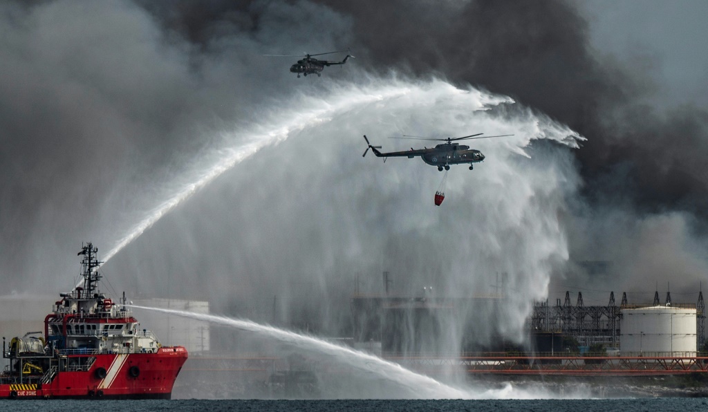 The Mexican firefighting vessel "Bourbon Artabaze" and helicopters battle to contain the days-old blaze at a fuel depot sparked by a lightning strike in Matanzas, Cuba