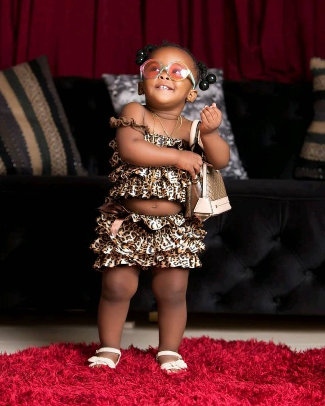 Kid fashionista: Baby Maxin poses with her cute pink handbag in latest photo