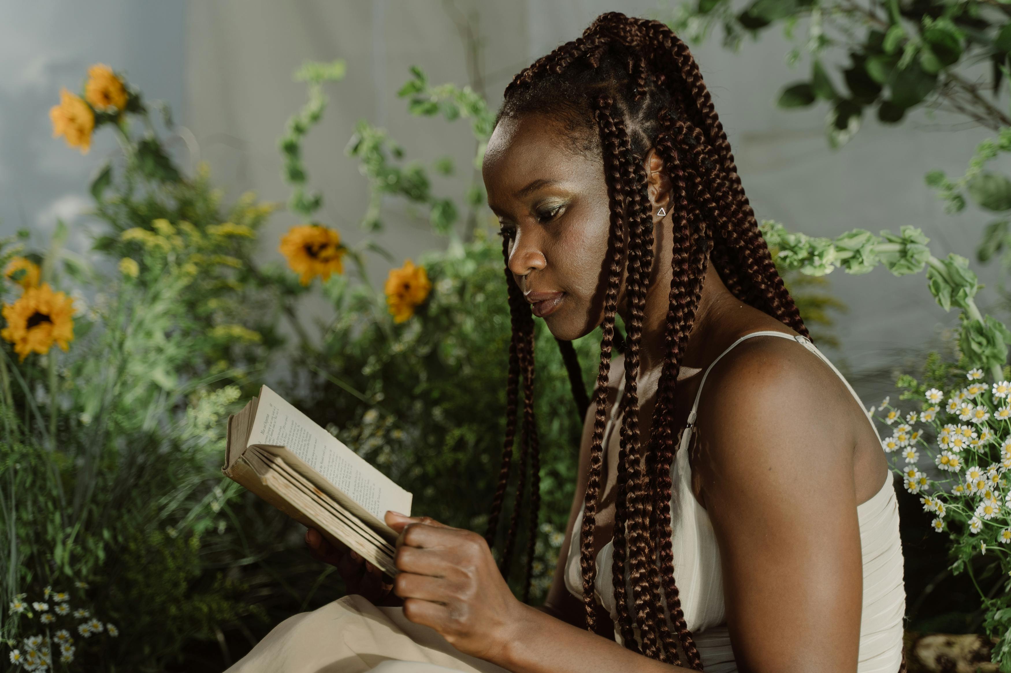 A young woman with braided hair reading a book
