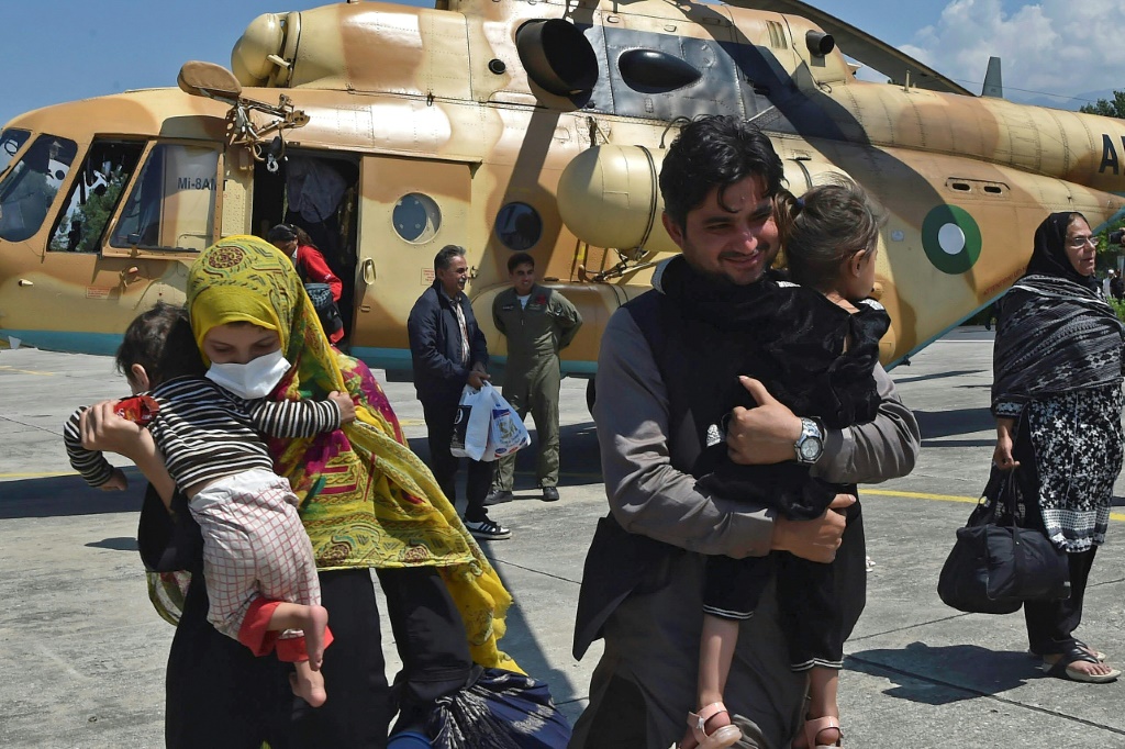 Local tourists disembark from a Pakistani army helicopter after they were rescued from  flood-hit tourist areas in the north