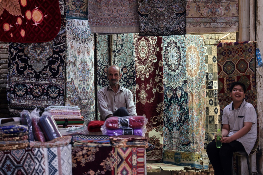 A rug vendor waits for customers in the old market of Iran's central city of Yazd