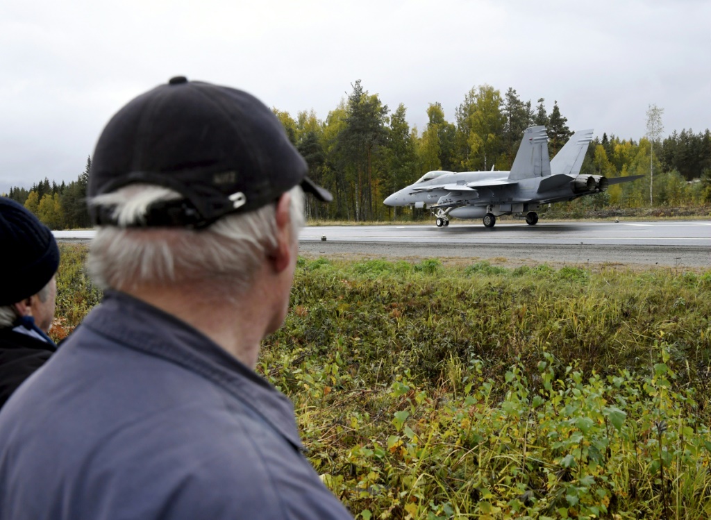 A Finnish air force fighter jet lands on a highway