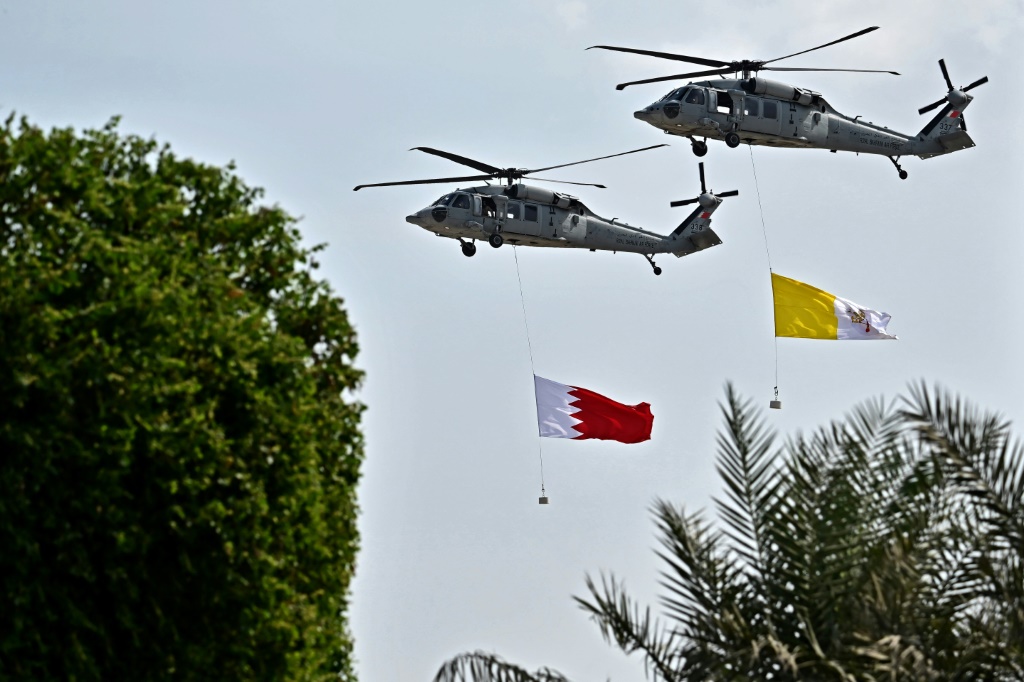 Helicopters of the Bahraini Royal Guard fly Bahrain and Vatican flags during a welcome ceremony at Sakhir Royal Palace