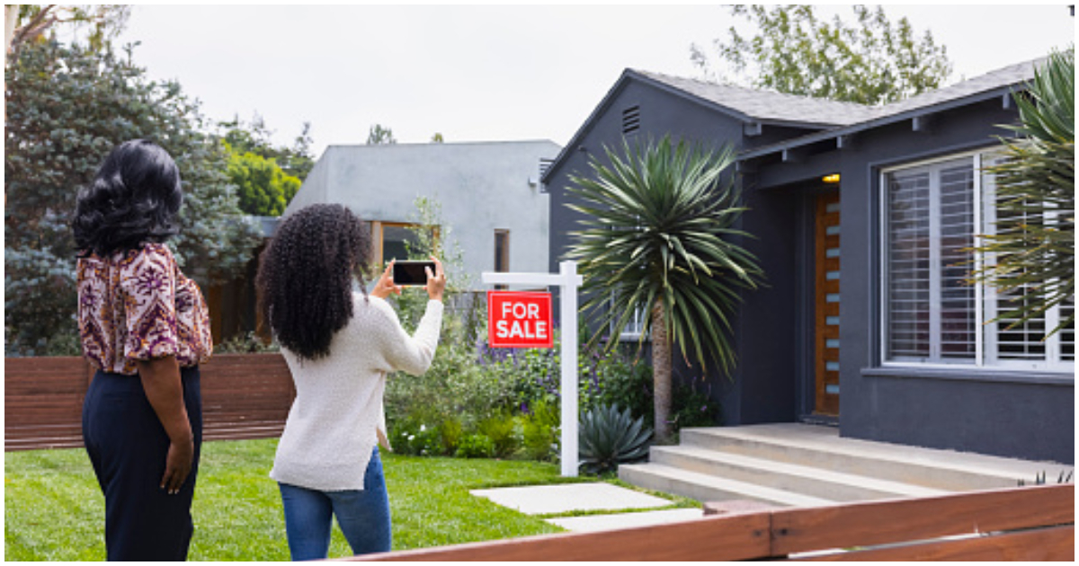A woman takes a picture during the property viewing process