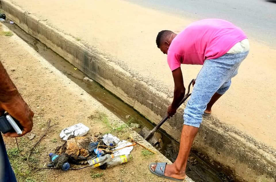 Kasoa MCE forces 'fine' Ghanaian man to clean gutter and street for dumping rubbish (photos)