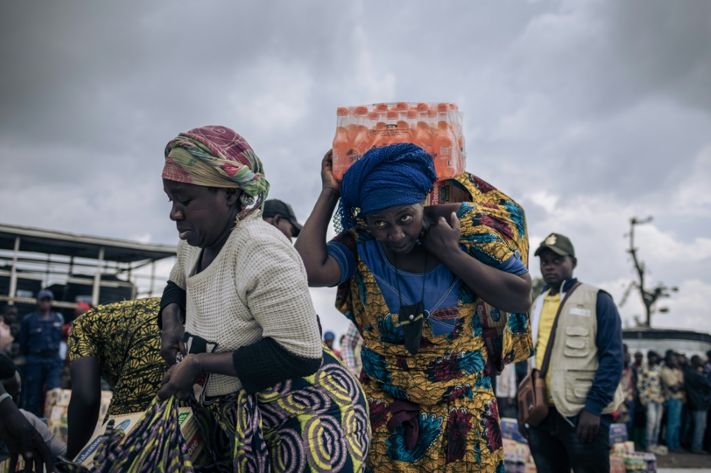 People who fled the advancing M23 receive a handout of biscuits and soda at an informal camp in northern Goma