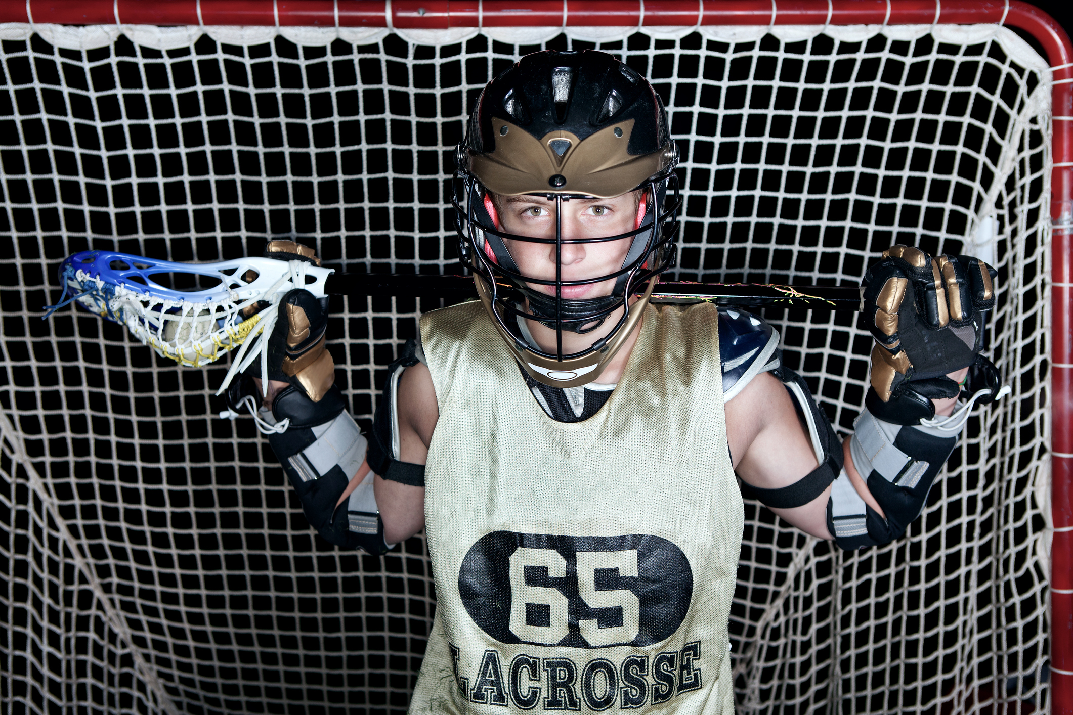 Lacrosse player dressed in uniform, holding a stick.