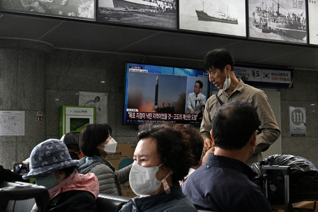 Passengers at a ferry terminal on South Korea's eastern island of Ulleungdo watch television footage of a North Korean missile test