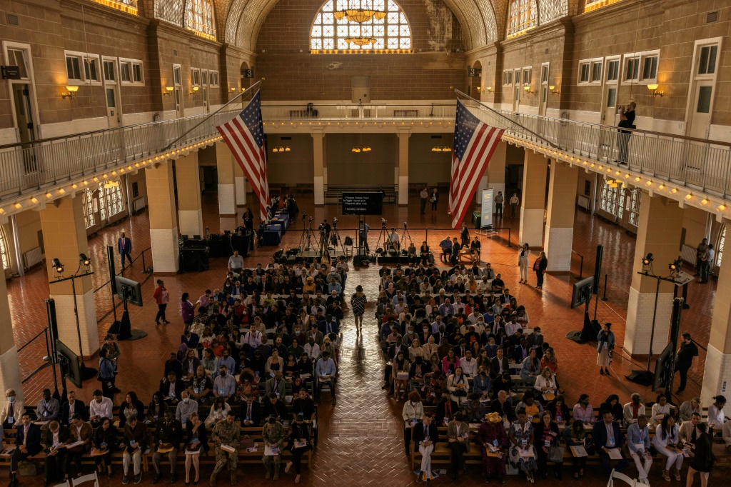 New US citizens attend a naturalization service on Ellis Island