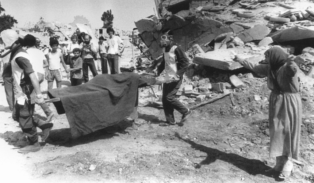 In this file photo taken on September 19, 1982, a Palestinian woman cries while civil defence workers carry the body of her relative killed in the Sabra and Shatila massacre