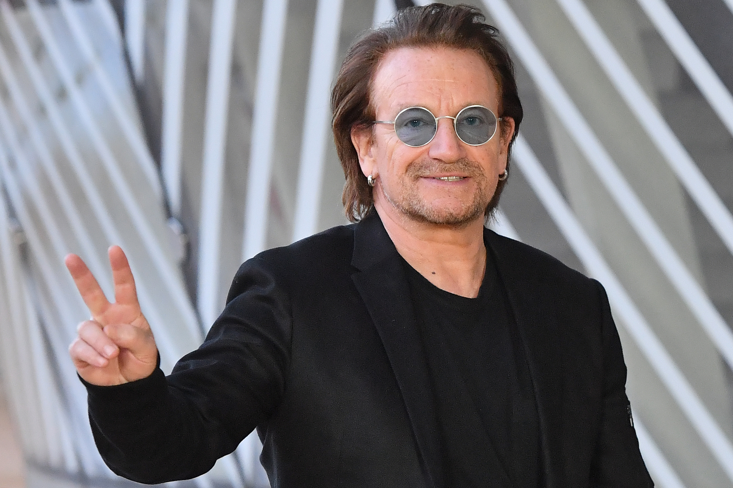 Bono flashes the Victory sign upon his arrival