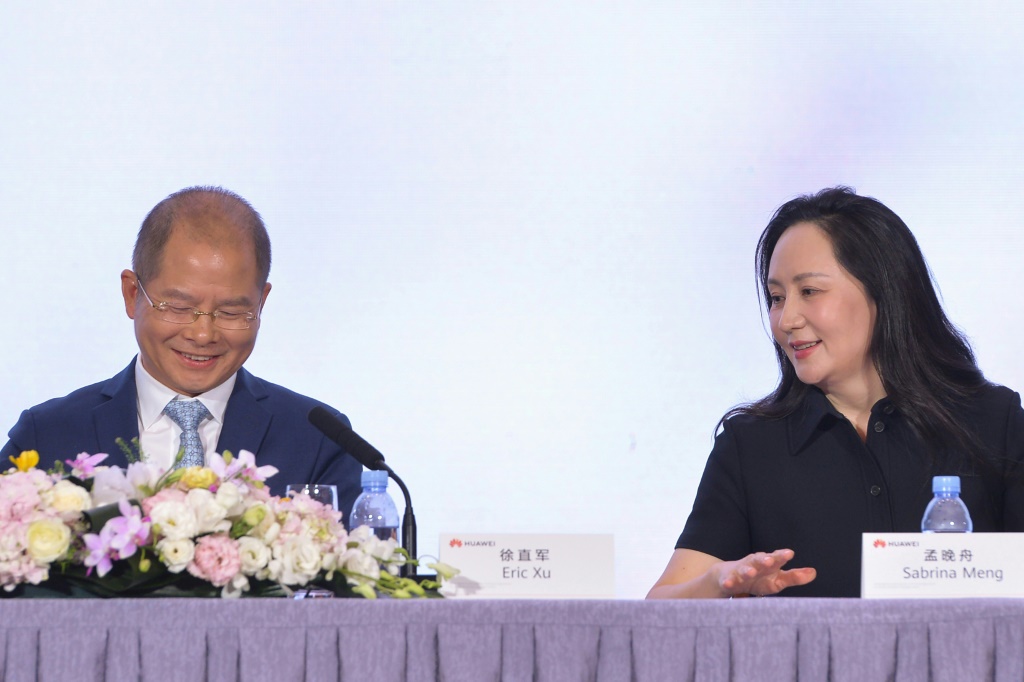 Eric Xu (L), Huawei deputy chairman and current rotating chairman, speaks with Huawei's Meng Wanzhou after a company press conference on March 31, 2023