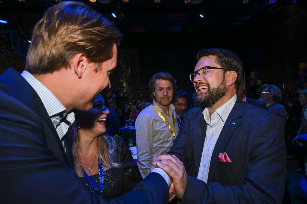 The leader of the Sweden Democrats, Jimmie Akesson (R), celebrates at the party's election night gathering in Nacka, near Stockholm