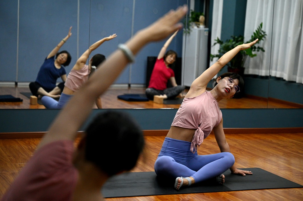 Feng Jing (R) quit her tech job to become a yoga teacher