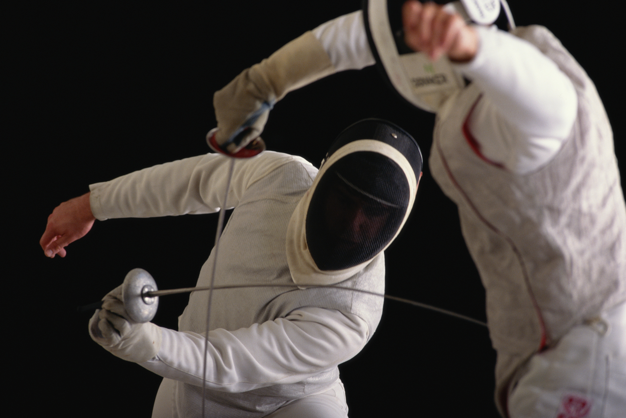 A fencing match between two competitors, both in fencing gear.