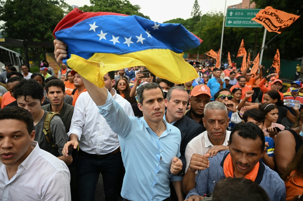 Venezuelan opposition leader Juan Guaido waves a national flag during a demonstration to demand a date for presidential elections in Caracas in October 2022