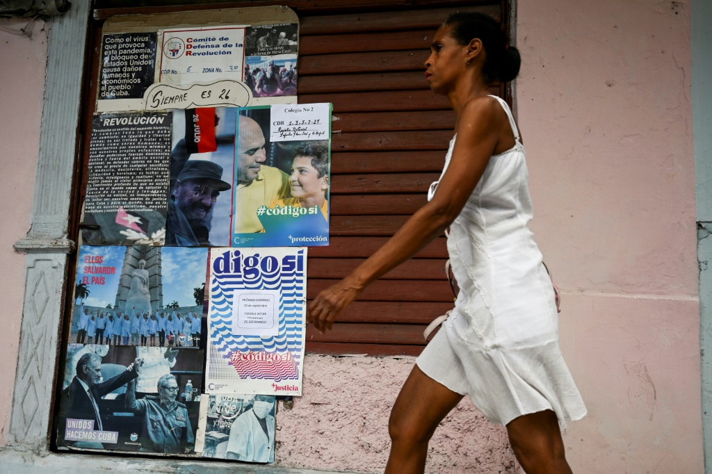 A woman walks past a sign in Havana in favor of the new Family Code