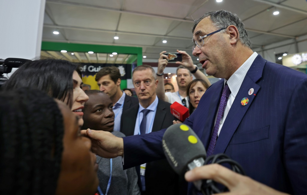 Total Energies CEO Patrick Pouyanne (R) speaks with activists at the COP27 UN climate conference where he was heckled by others angered by the presence of fossil fuel lobbyists