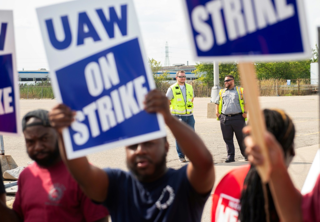 UAW members and workers at Mopar Parts Center Line, a Stellantis parts distribution center in Center Line, Michigan, hold signs after walking off their jobs on September 22, 2023