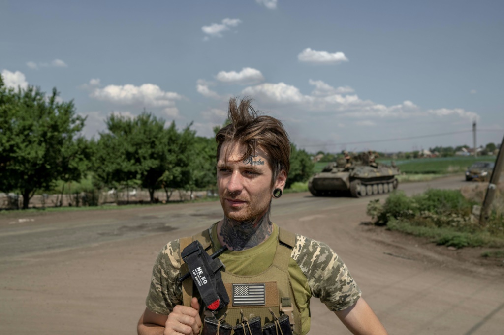 The word 'Freedom' is etched in cursive tattoo ink on Ukrainian soldier Mykhailo's forehead