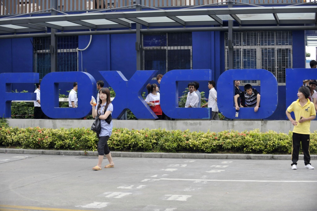 Chinese workers are seen outside Foxconn's factory in Shenzhen, in southern Guangdong province, in this file photo