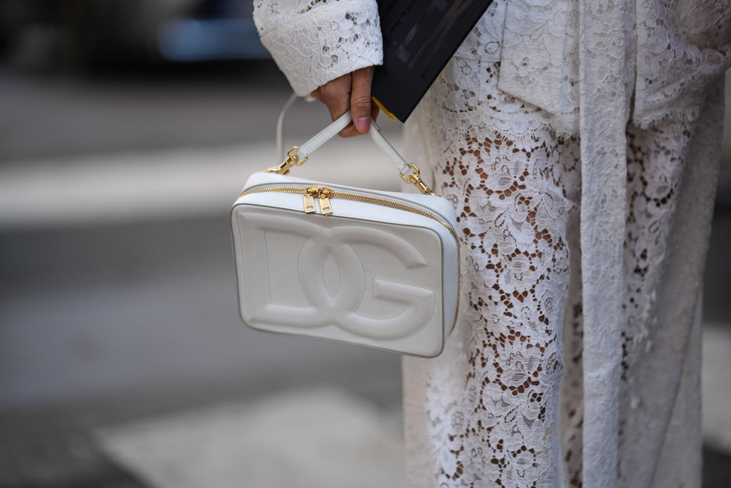 White Dolce & Gabbana bag with gold hardware and logo detail.