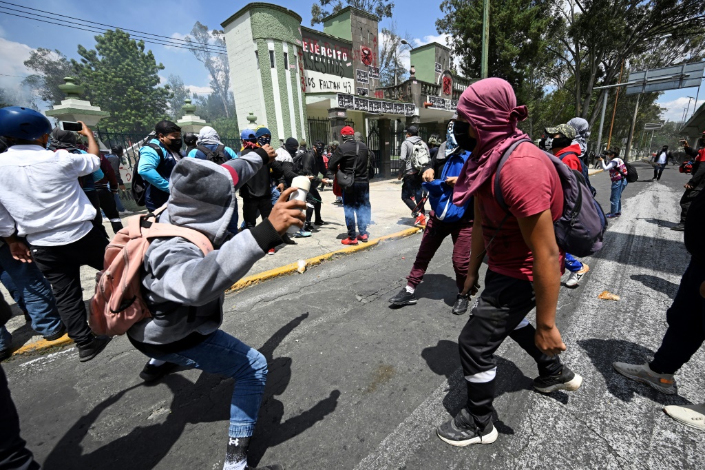Protesters throw stones and homemade explosive devices at a Mexican military camp during a demonstration over the disappearance of 43 students in 2014