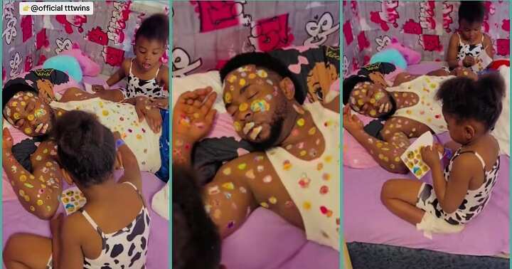 Twin girls decorate their father's body with stickers at home
