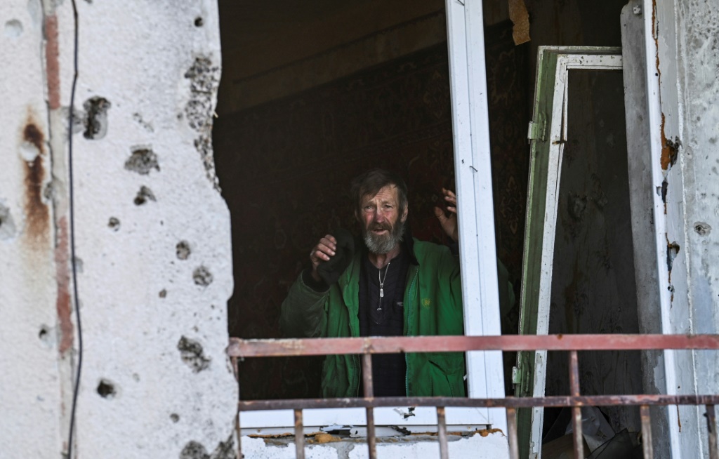 A man gestures inside a damaged building in Hrakove village in September 9, 2022, amid Russian invasion of Ukraine