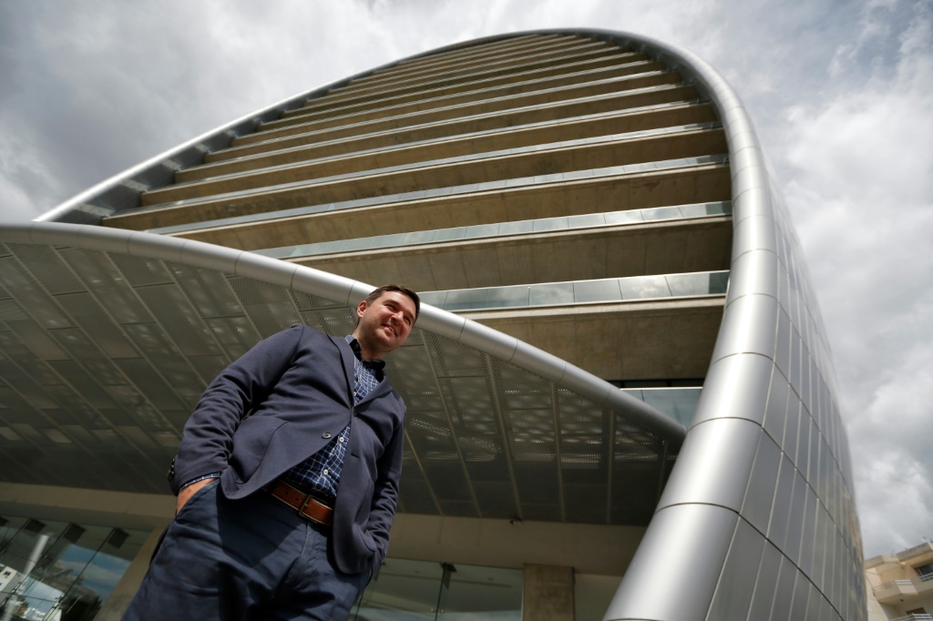 Russian IT specialist Dmitri Leonov poses next to 'The Oval', part of the transformed Limassol skyline
