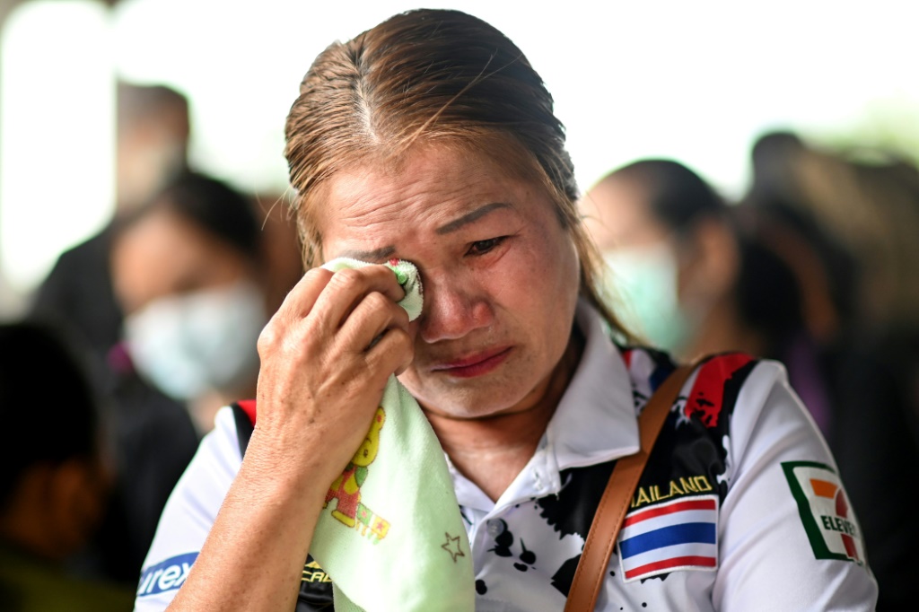 The relative of a victim cries outside the nursery