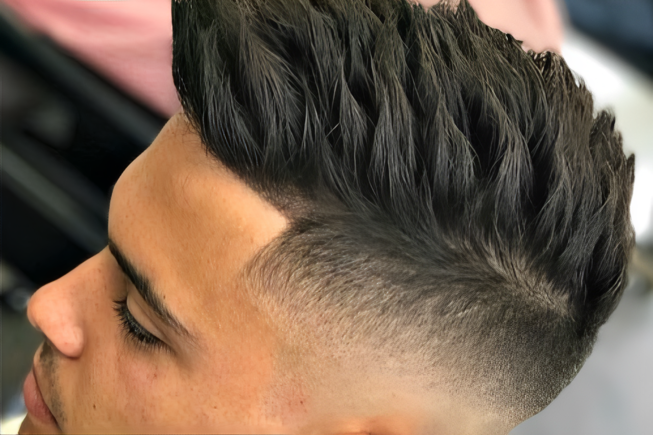 A young man is rocking a fade and spiky haircut