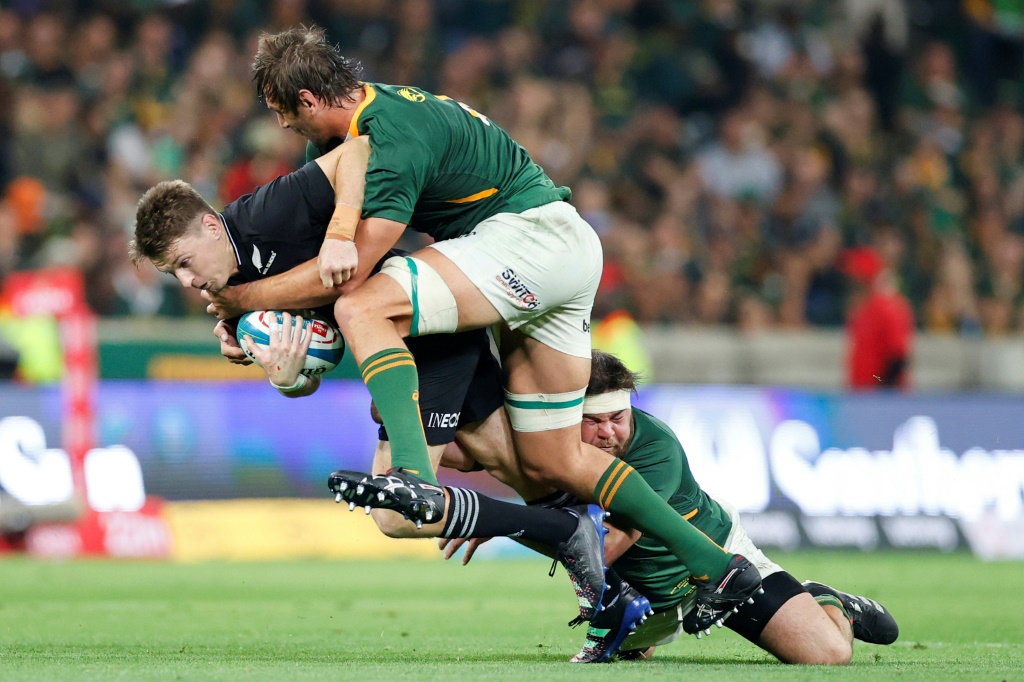 South Africa lock Eben Etzebeth (C) and prop Frans Malherbe (R) tackle New Zealand fly-half Beauden Barrett (L) during the Rugby Championship match in Mbombela on August 6, 2022.