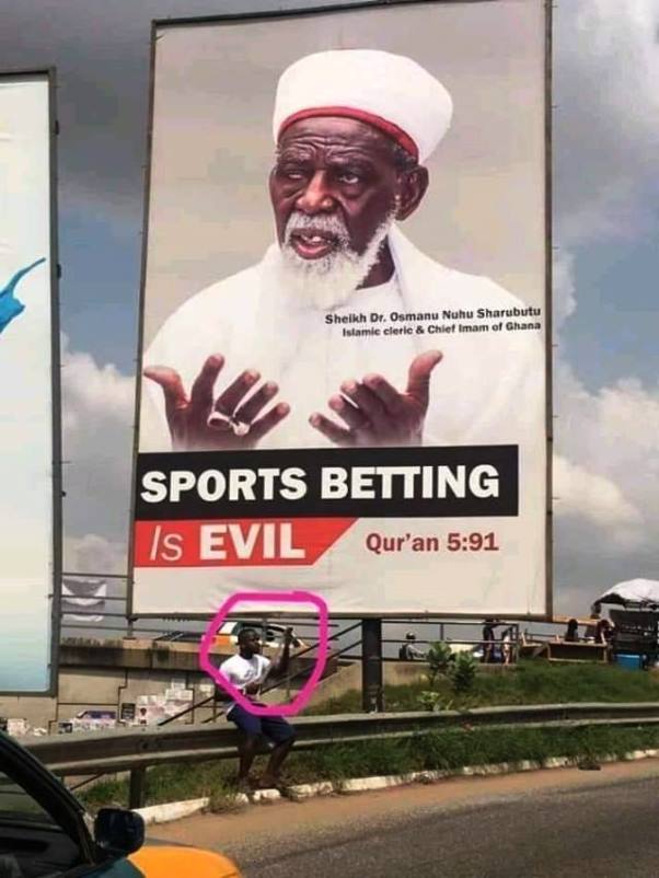 Man ‘defies’ Chief Imam and checks bet slip under billboard which says betting is evil (Photo)