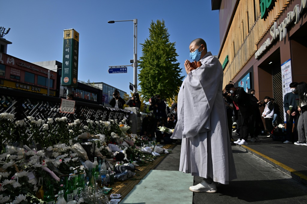 A Buddhist nun prays in tribute to the victims