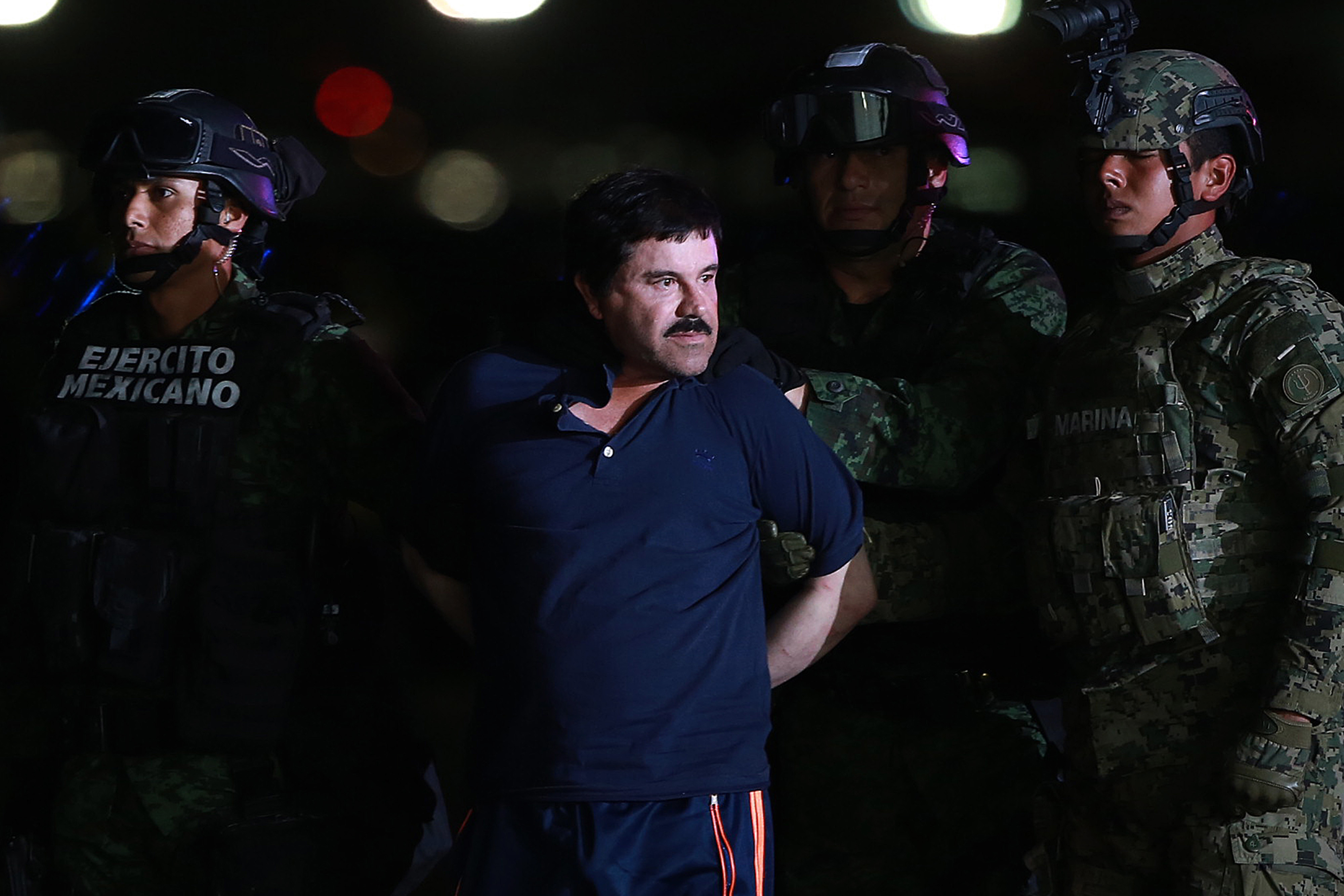Joaquin Guzman (centre) is escorted by Mexican security forces at a Navy hangar in Mexico City