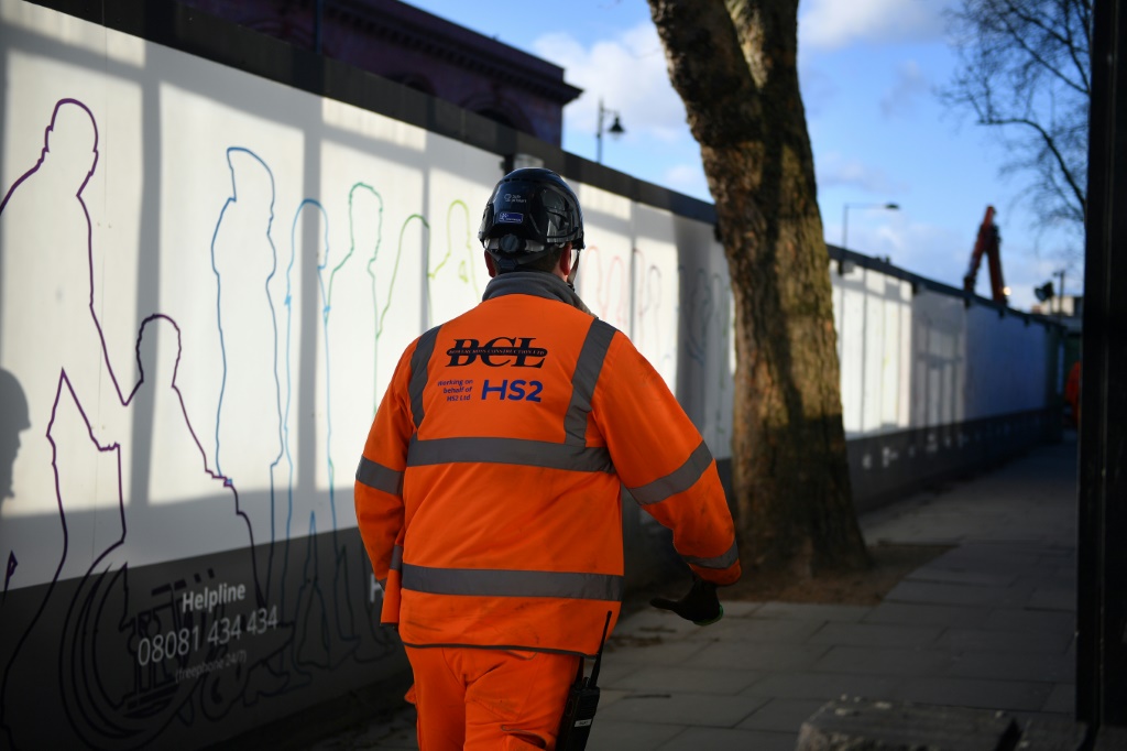 A construction worker walks outside a construction site for a section of Britain's HS2 high-speed railway project at London Euston train station