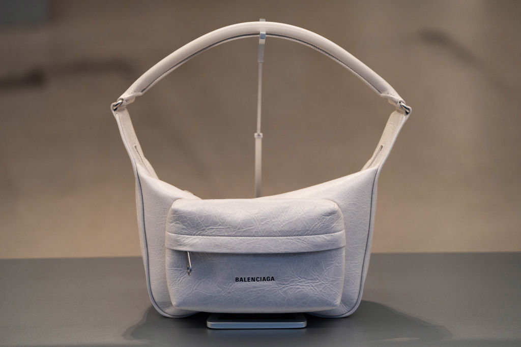 White Balenciaga Raver handbag with white handle on a table.