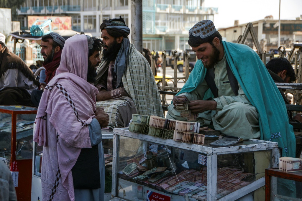 A money changer counts Afghani banknotes at an exchange market in Kandahar in December 2021 amid the sidelining of the country's central bank by global powers following the Taliban's return to power