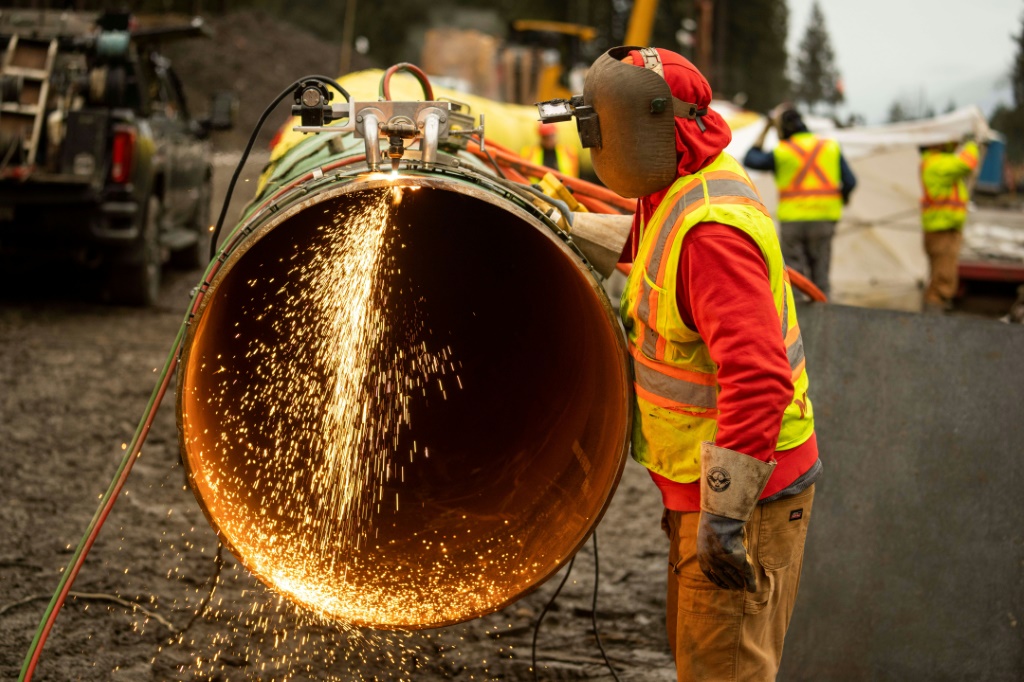 This January 17, 2023, image courtesy of Trans Mountain Corporation shows a welder working on a pipeline in Bridal Falls, British Columbia, Canada. The pipeline will carry 600,000 additional barrels per day of oil from Alberta to Canada's Pacific coast for shipping overseas