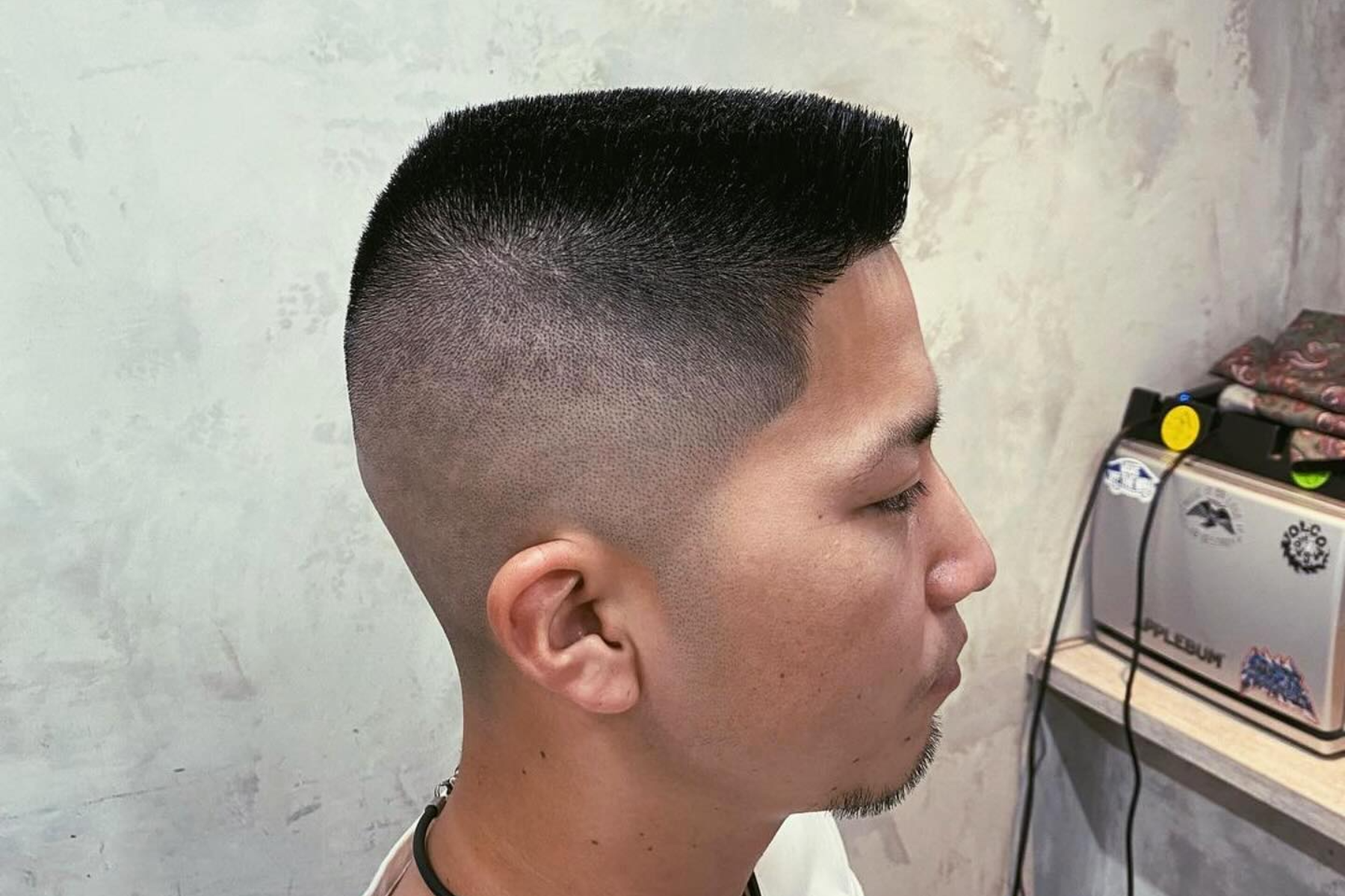 An Asian man with a flat top haircut