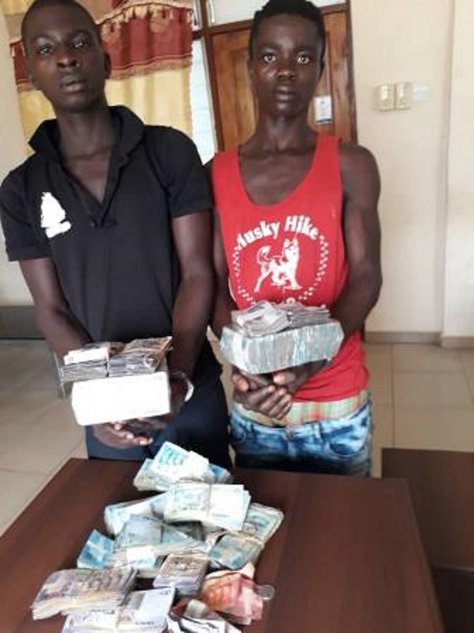 Two suspects holding stolen money