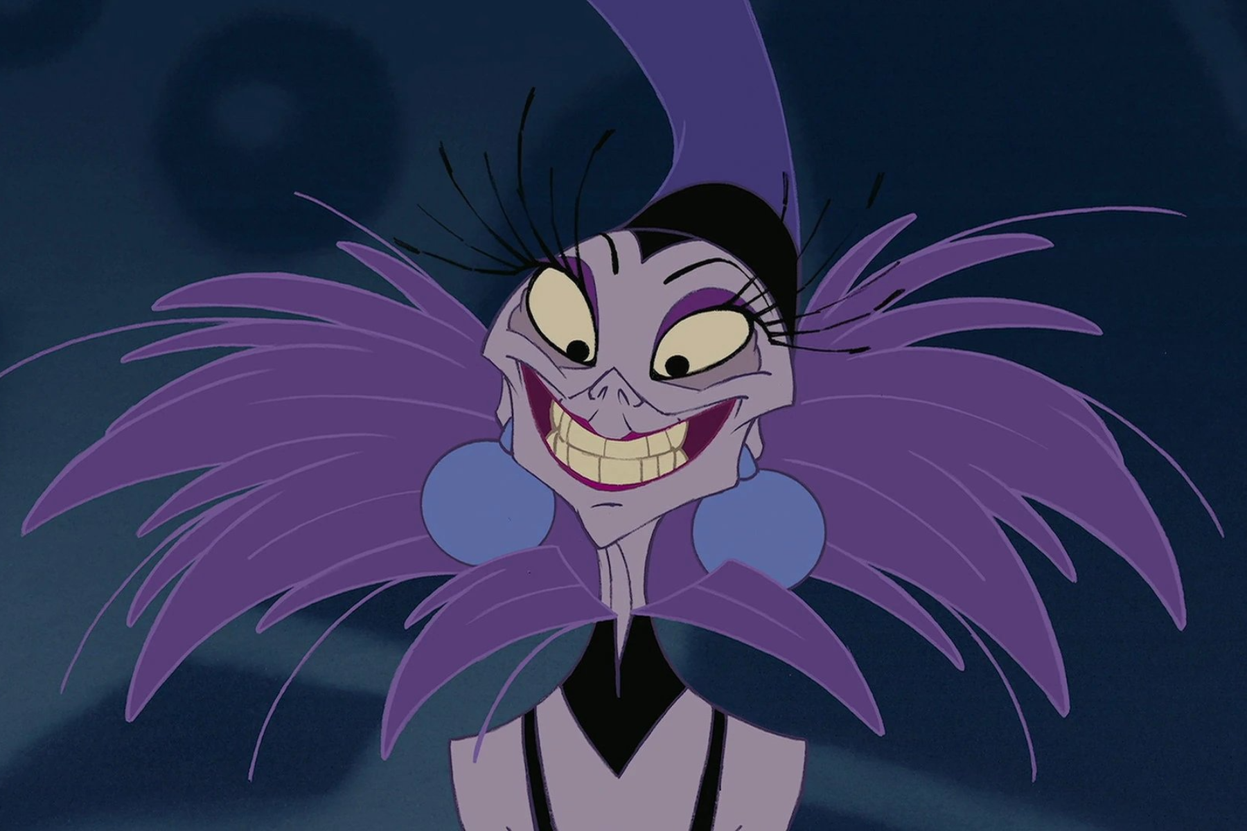 Yzma smiles against a blurred background