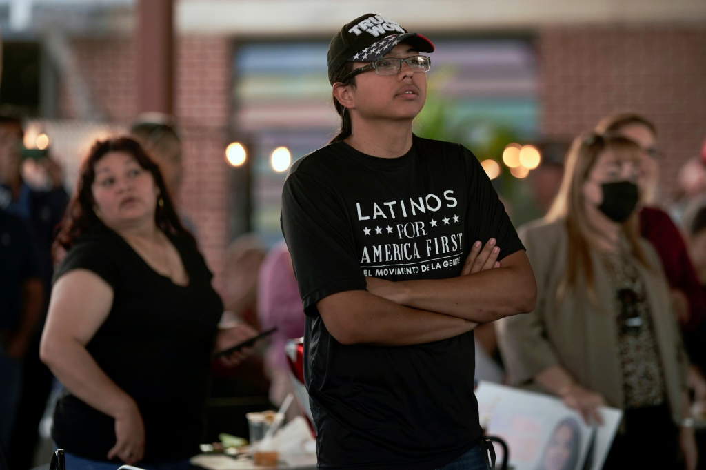 A man wearing a T-shirt that says, "Latinos for América First" attends a rally in McAllen, Texas, on October 10, 2022