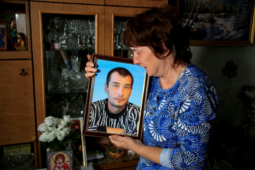 Galina Inkina cries holding a portrait of her late son, Denis, killed in a Kazakh mine