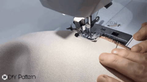 A tailor sewing the side seam of a circle skirt